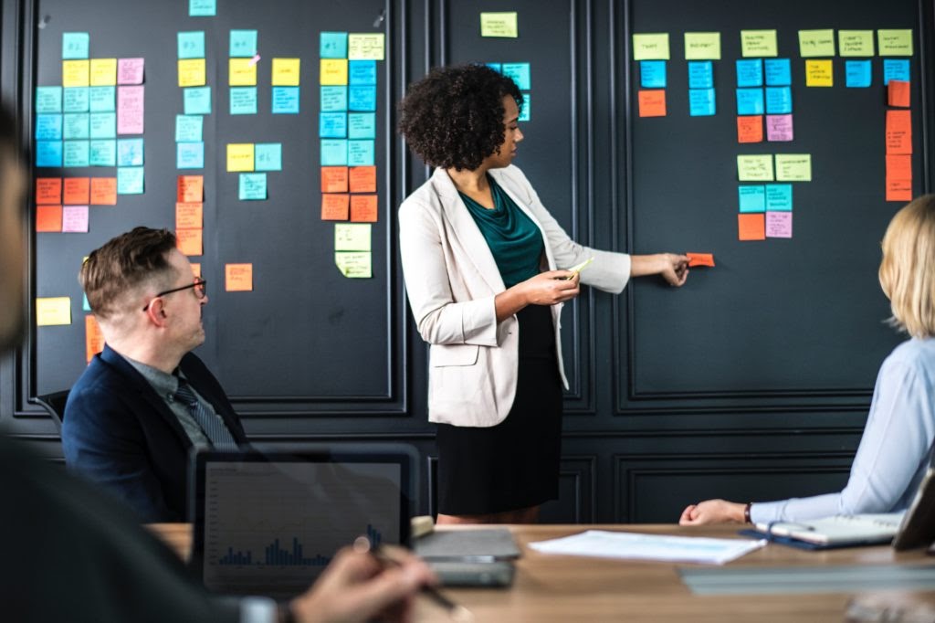 Femme collant un post-it sur un mur.